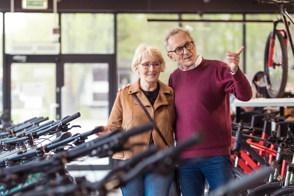voucher process, California E-Bike, man and woman pointing at bikes in a bike shop.